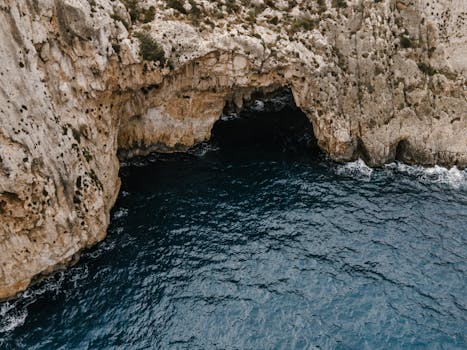 Stunning aerial view of Blue Grotto's cliff and azure waters in Il-Qrendi, Malta.