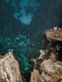 Stunning aerial view of the rocky cliffs meeting the vibrant blue sea in Malta.