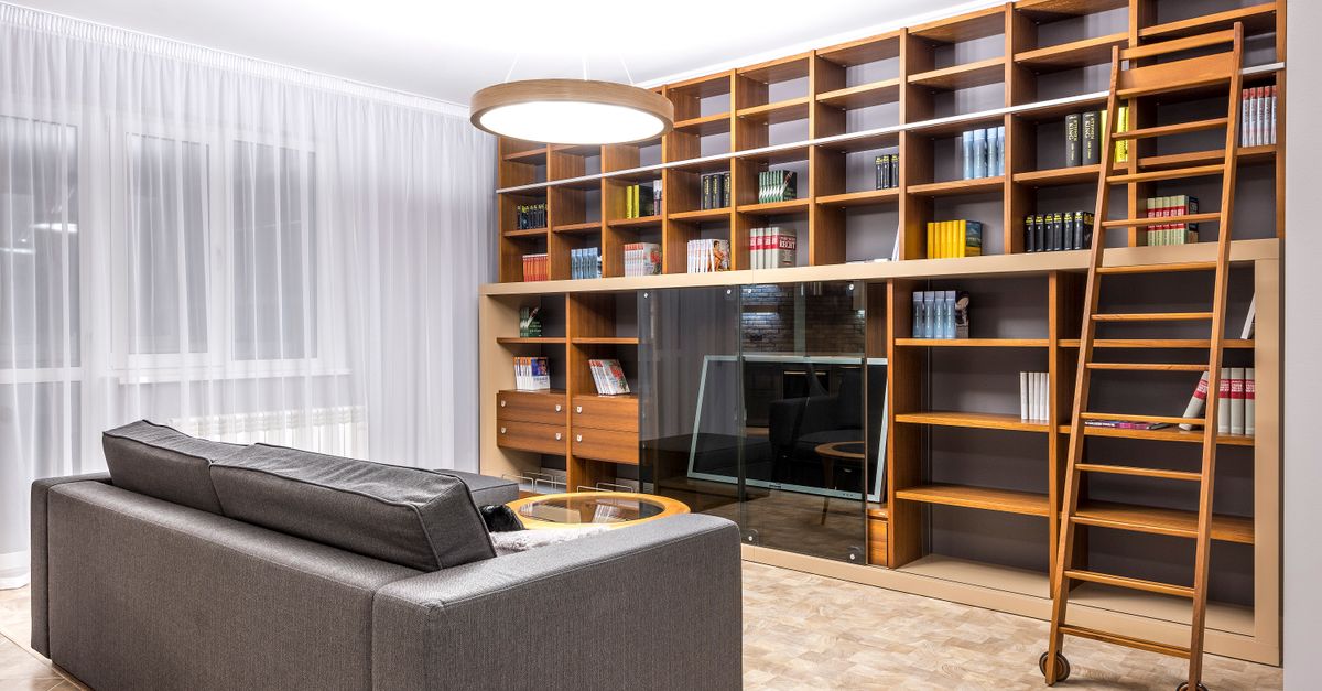 A well-built wooden bookcase styled in a living room.