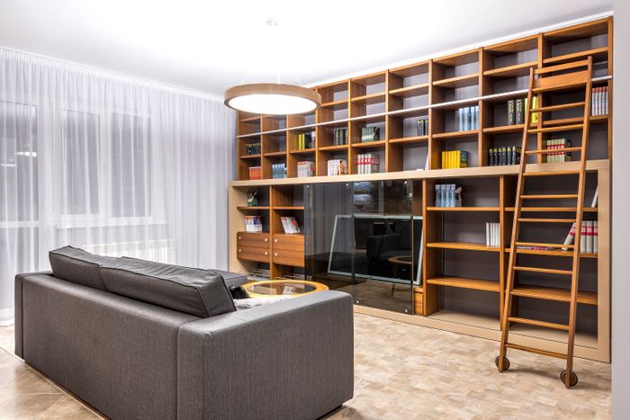 Floor-to-ceiling white oak built-in bookcase with integrated lighting in living room