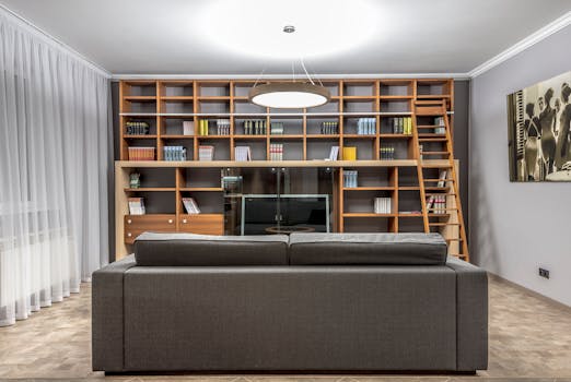 Stylish living room featuring a large bookshelf, sofa, and contemporary lighting.