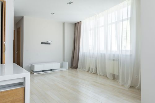 Free Bright modern minimalist apartment interior with large windows and sheer curtains. Stock Photo