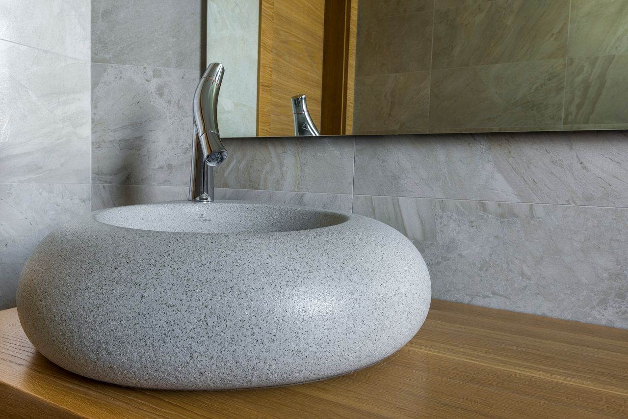 stone-vessel-sink-vanity Carved stone vessel sink on a wooden bathroom counter