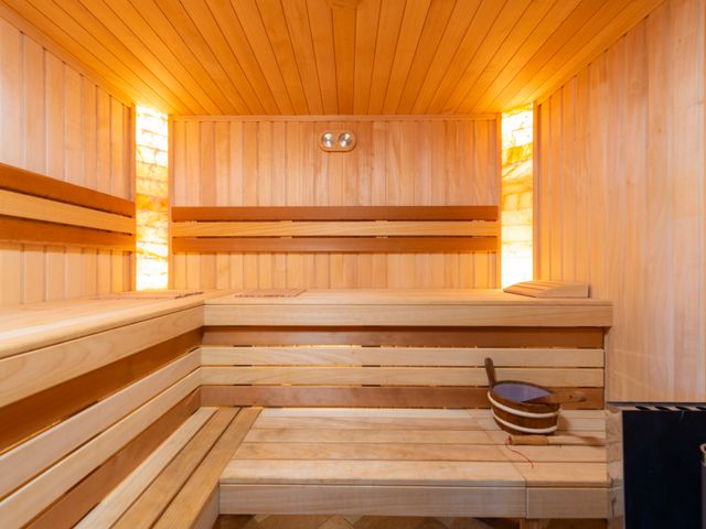 Empty cedar sauna benches lit from above