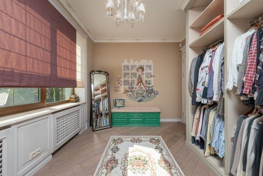 Elegant walk-in closet with clothes and a full-length mirror