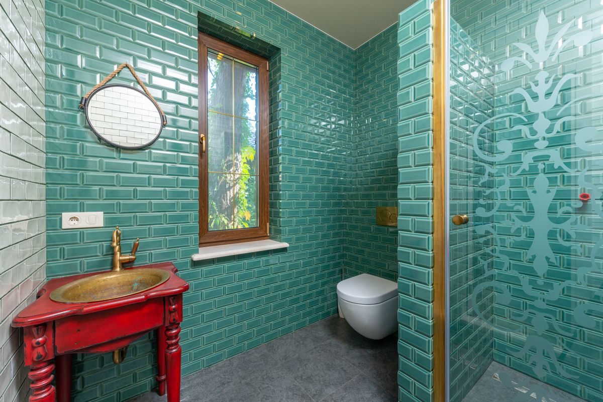 bathroom with green wall and tiled floor