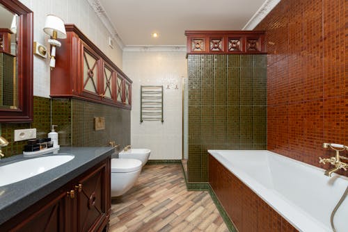 Green and Brown Bathroom With White Vanity and Bathtub