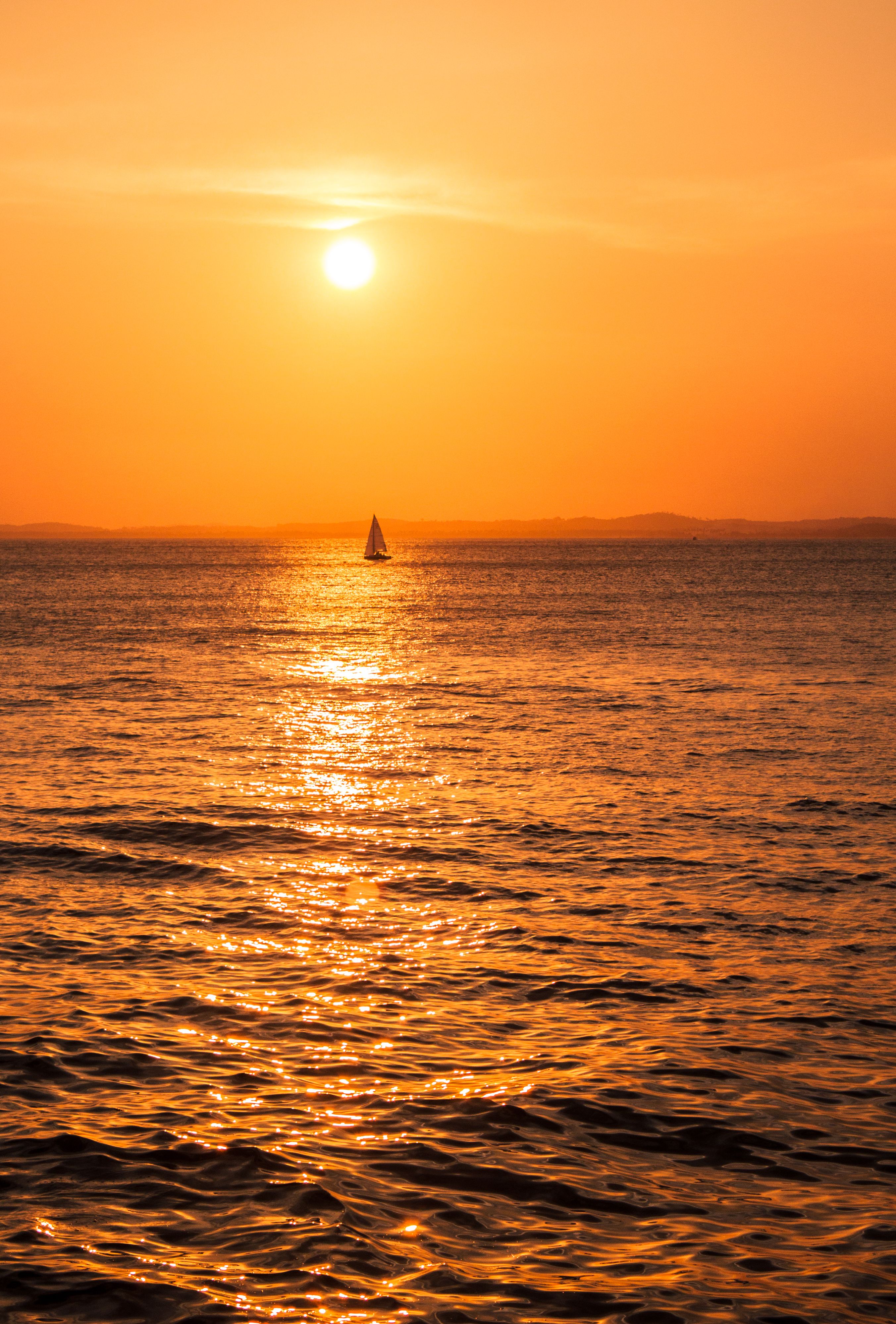 Sailboat gliding on the ocean at sunset