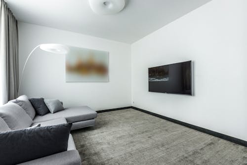 Gray Couch in a Carpeted Living Room With White Walls