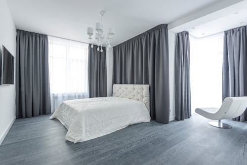 White Bed in a Bedroom With Gray Curtains