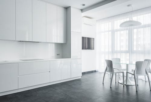 White Chairs and Glass Table Near White Cabinets