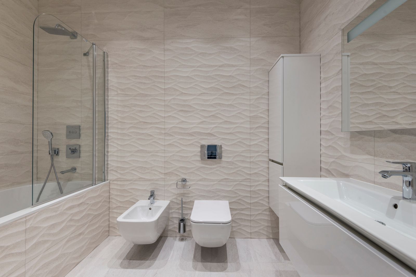 Minimal bathroom with two toilets and a wall-hung sink in a commercial-style washroom