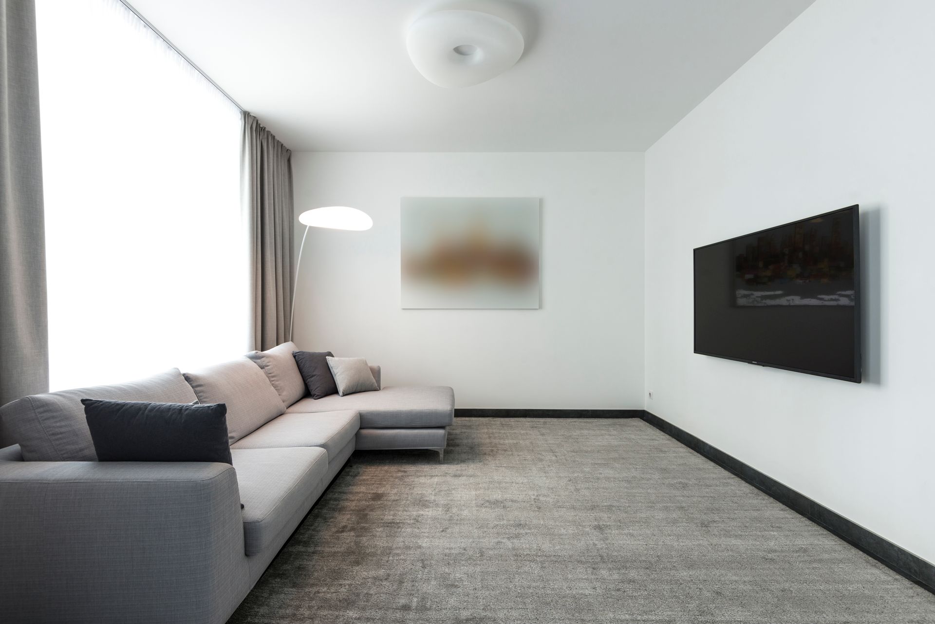 Contemporary living room with a gray sectional sofa and a wall-mounted TV