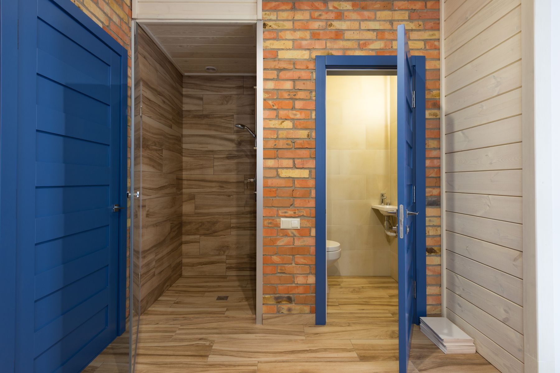 Contemporary bathroom with blue doors, warm wood and shower area