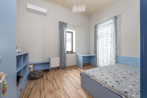 A Cozy Bedroom with Wooden Flooring