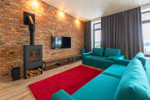 Free Modern living room featuring a stylish brick fireplace and vibrant turquoise sofas. Stock Photo