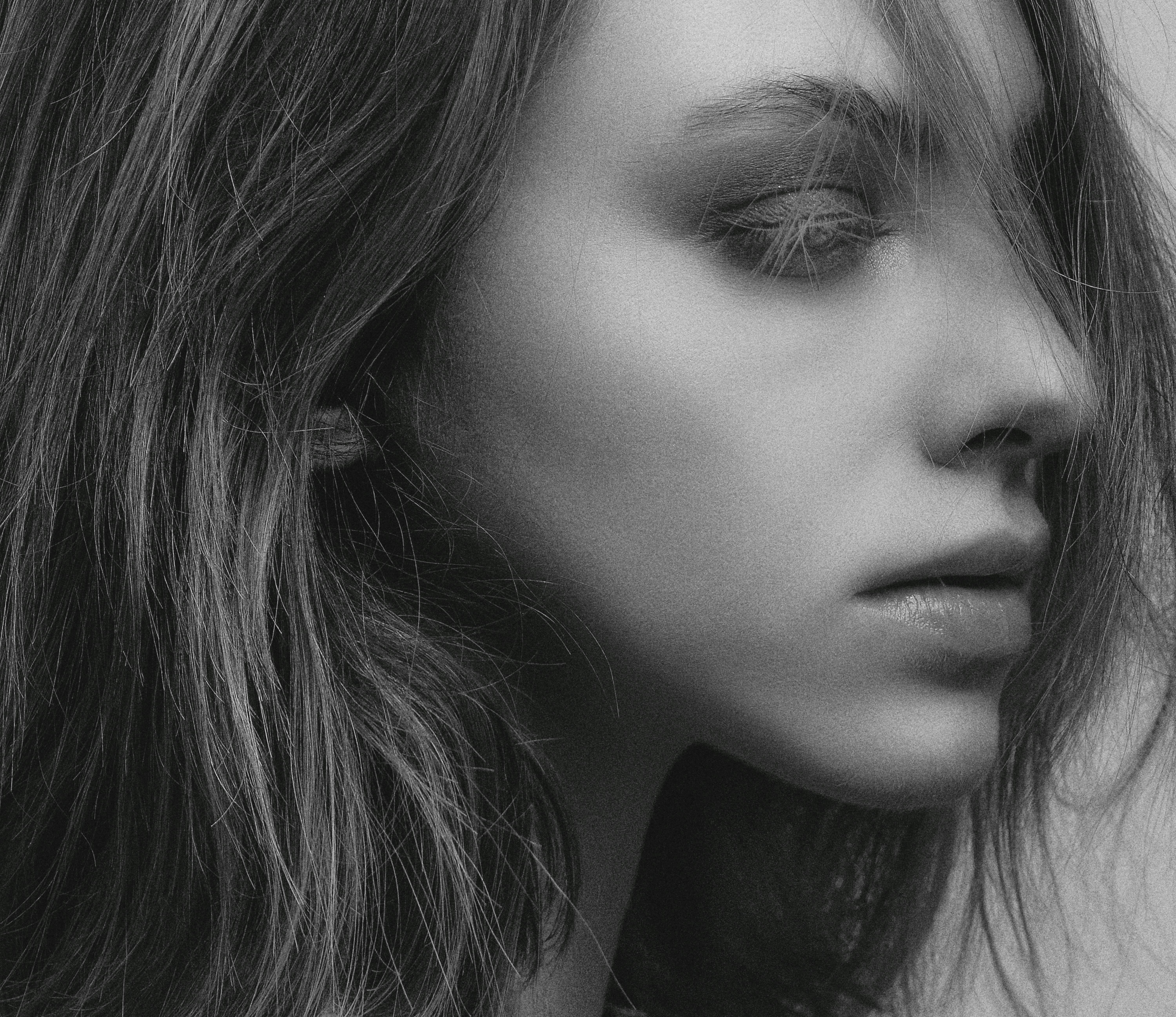Elegant black and white portrait of a woman with expressive eyes and flowing hair.