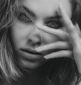 Elegant black and white portrait highlighting woman's expressive eyes and thoughtful pose.