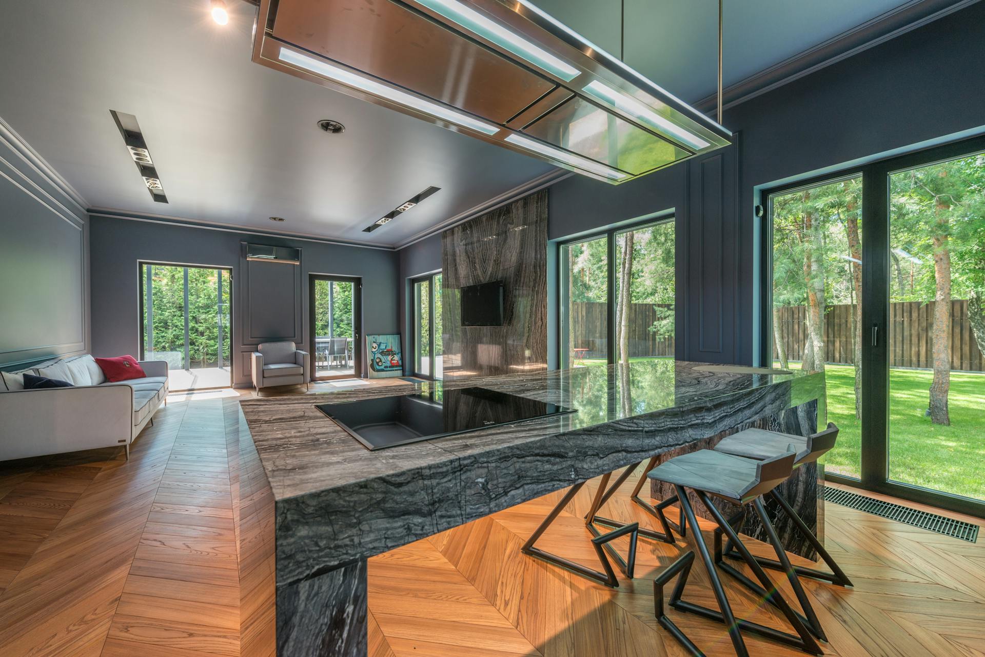 Contemporary living room featuring large marble kitchen island and natural lighting.