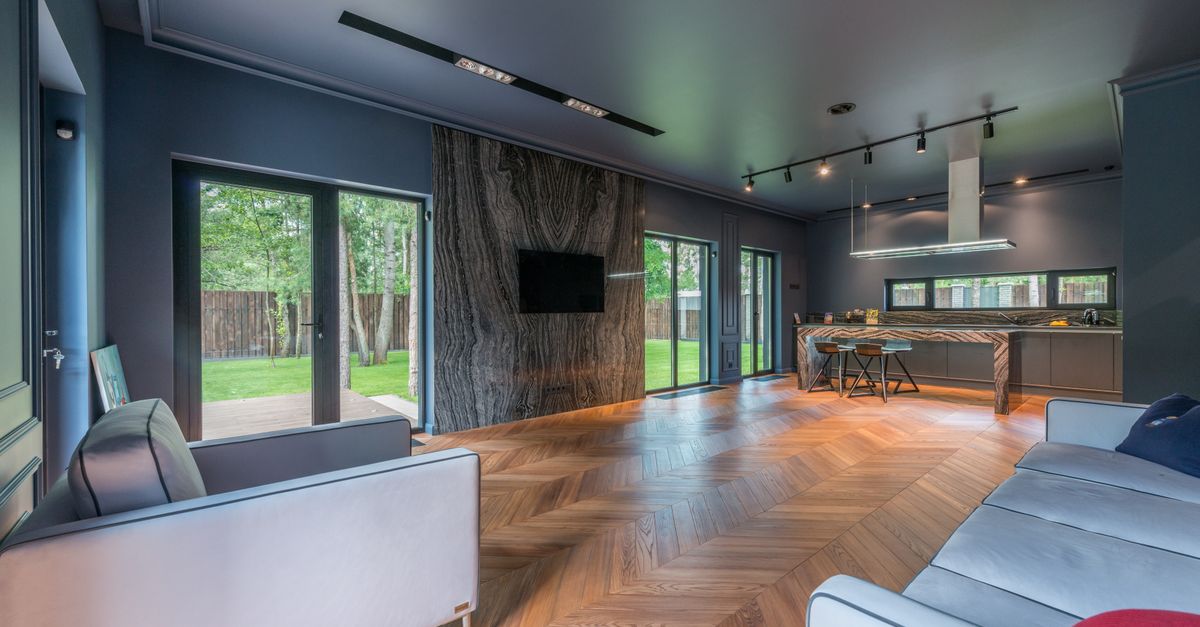 Contemporary living room featuring wooden floors, large windows, and stylish decor.