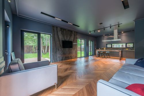 Free Contemporary living room featuring wooden floors, large windows, and stylish decor. Stock Photo
