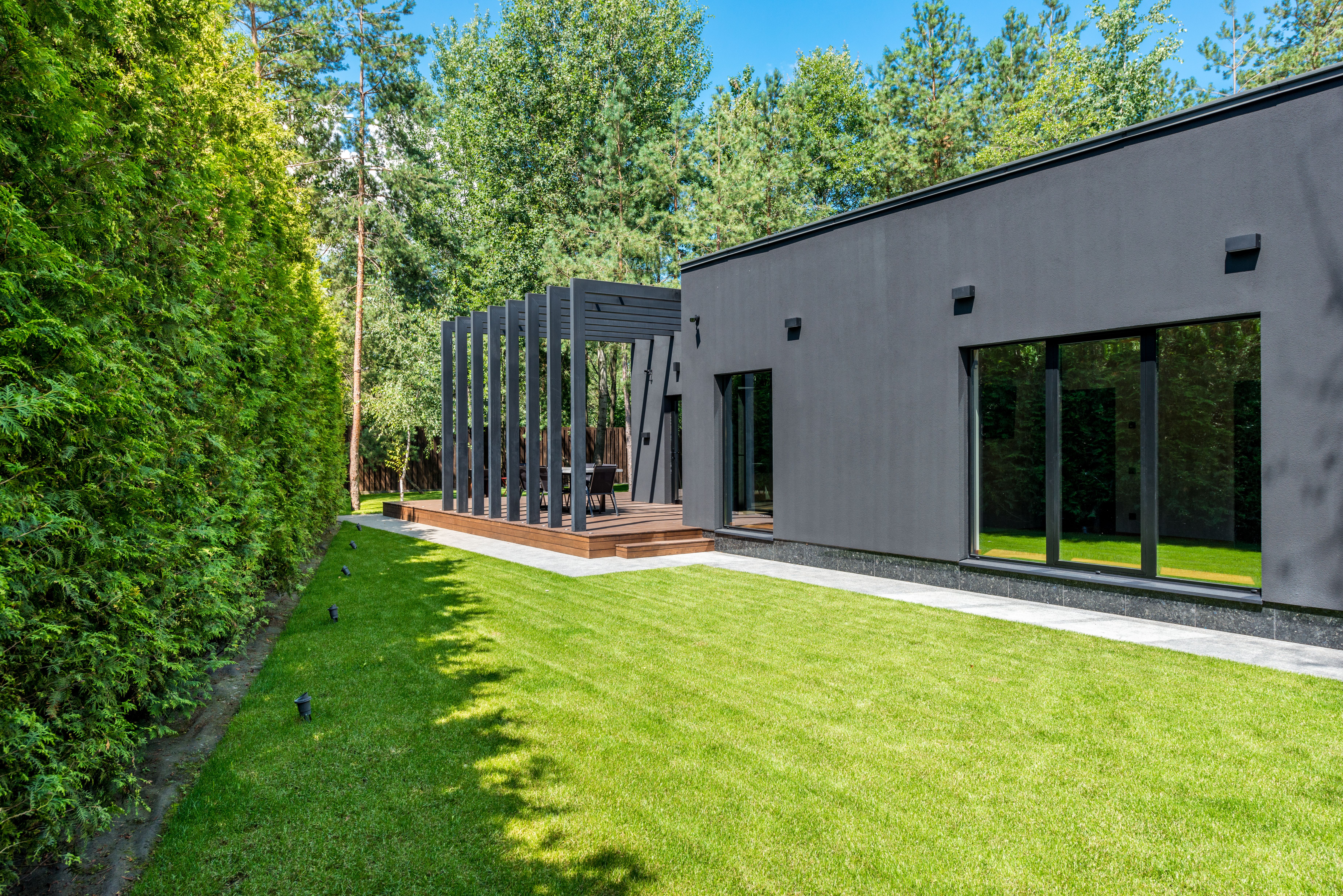 Contemporary home exterior with lawn and connector pergola