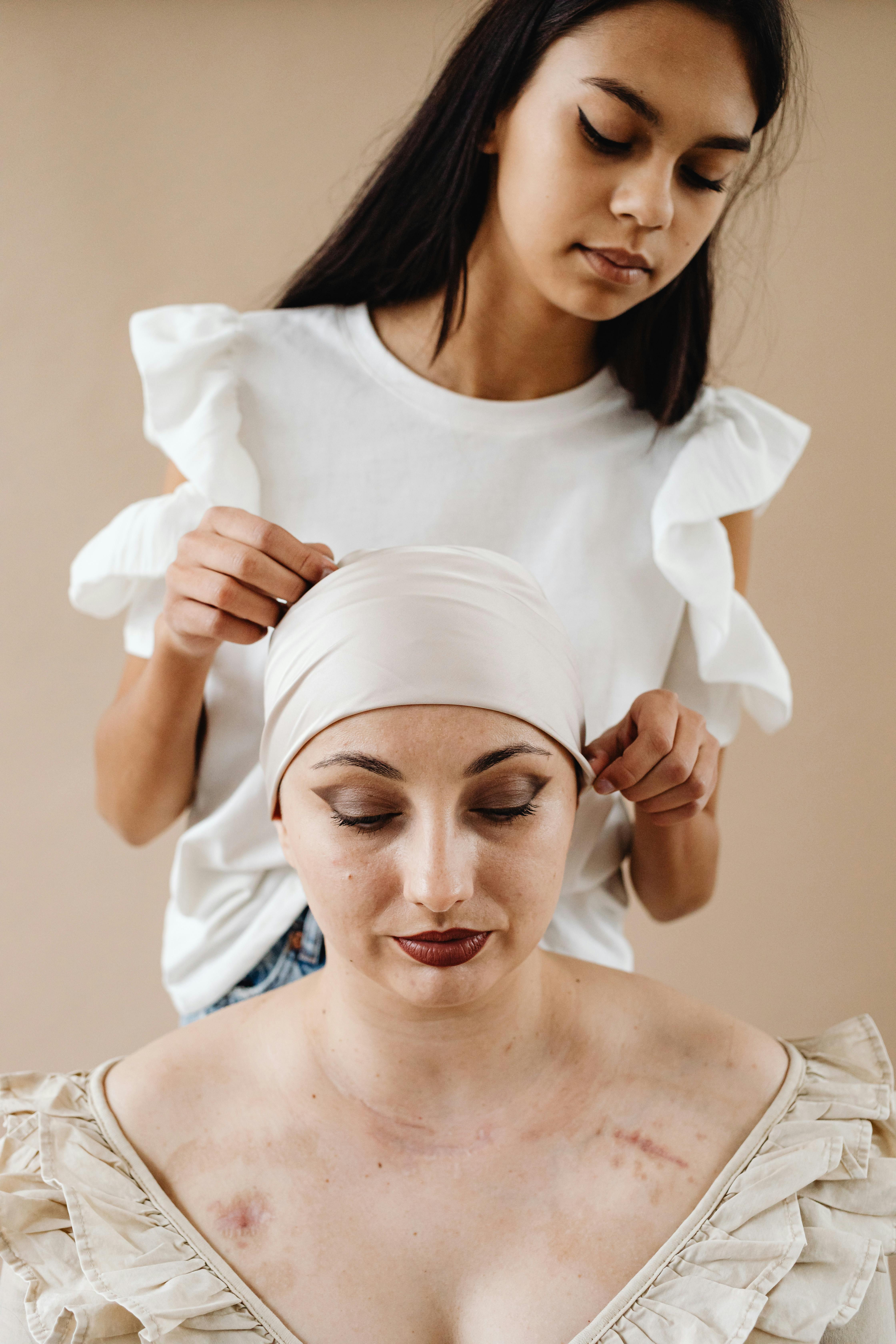A touching scene of support between a teenage girl and a woman wearing a headscarf, highlighting strength and care.