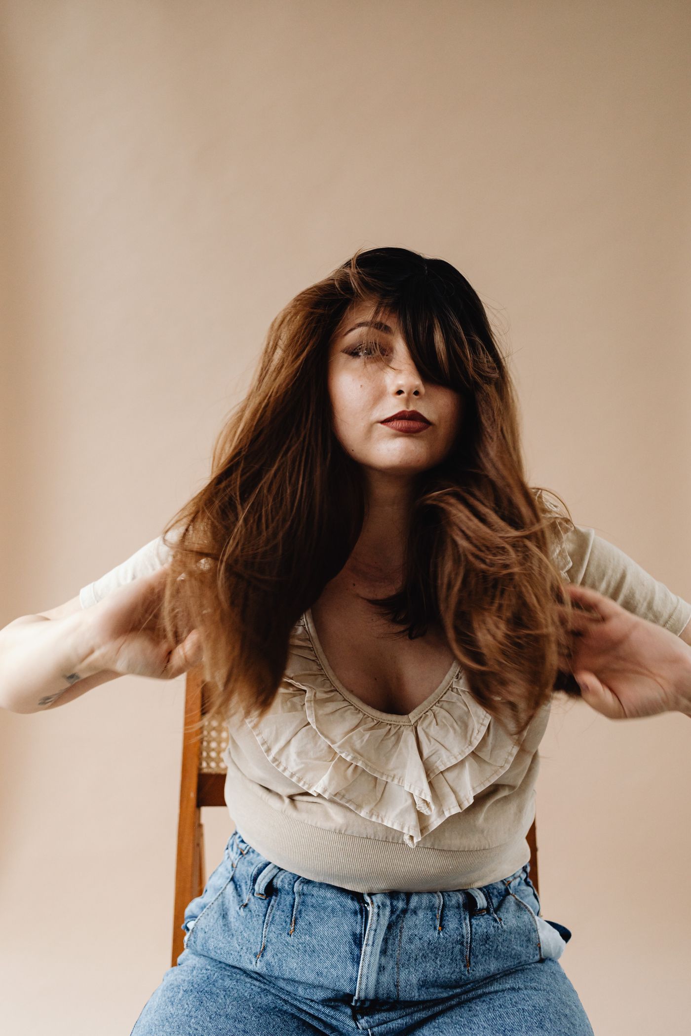 Woman styling a long brunette wig