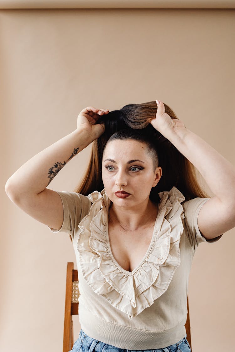 Portrait Of Woman Holding A Wig Above Her Head