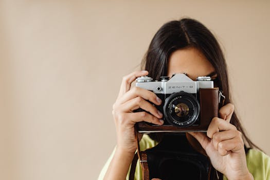 Close-up of a woman holding a vintage camera, capturing the essence of photography art.