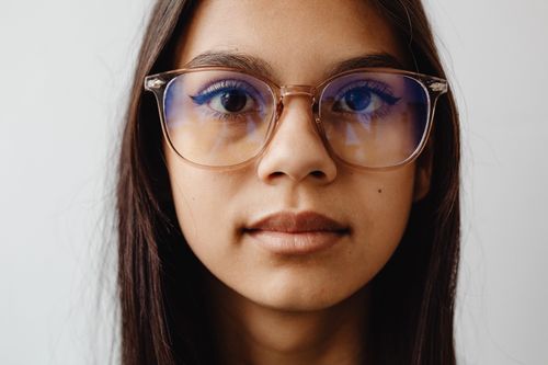 Free Close-up portrait of a girl with glasses, highlighting her eyes and expression. Stock Photo