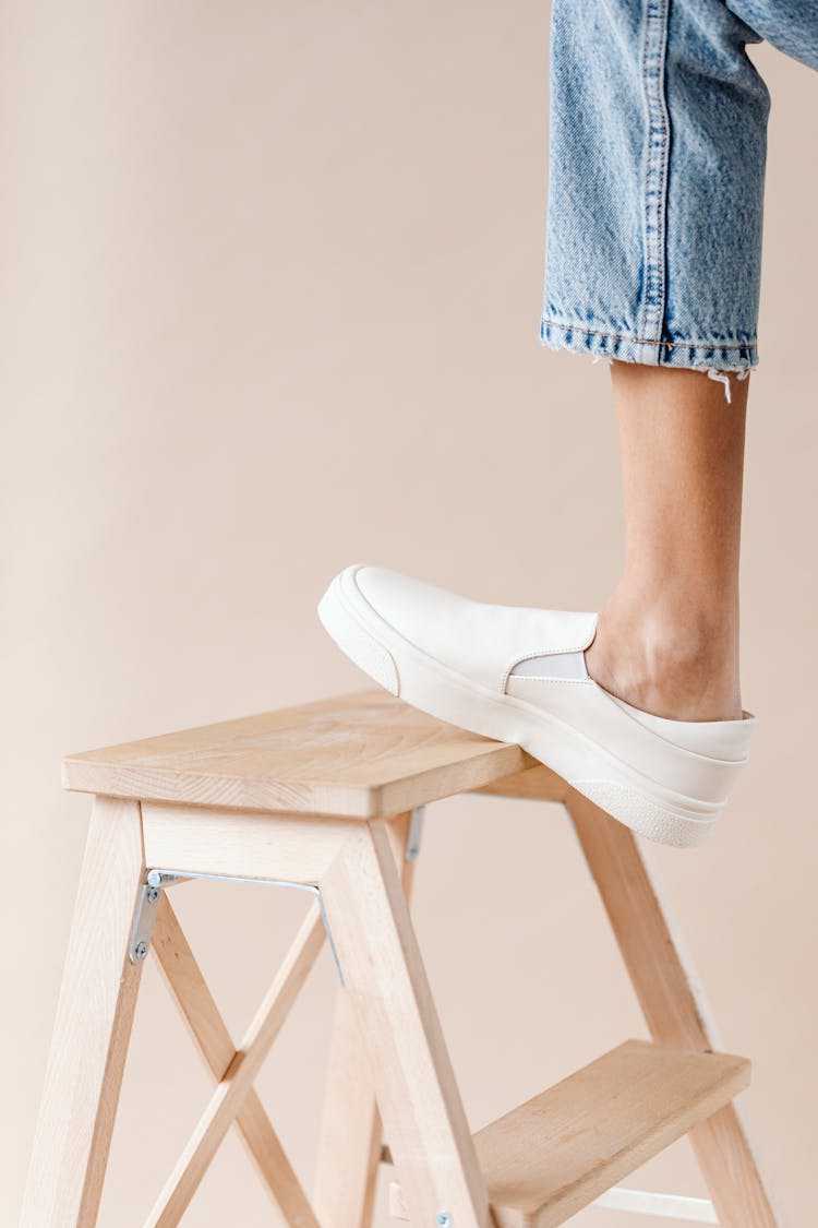 Woman Leg In White Shoe On Wooden Ladder