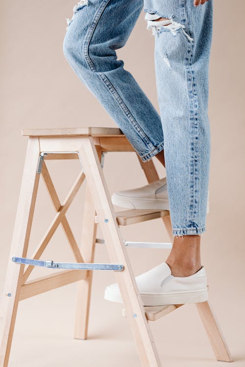 Free Person Standing on a Wooden Ladder Stock Photo