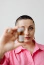A Woman in a Pink Top Holding a Medicine Bottle