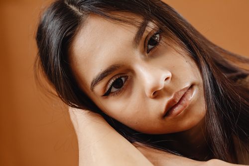 Free Close-up portrait of a young woman with long hair and expressive eyes. Stock Photo
