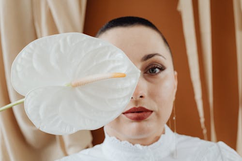 A Woman Holding a White Anthurium Flower