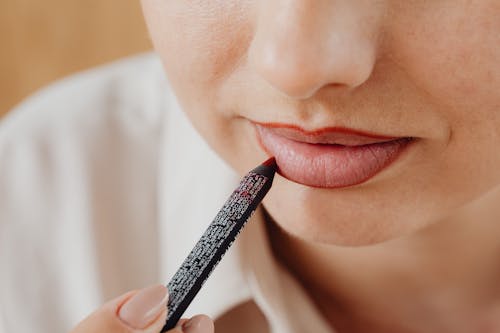 Free A Woman Applying Lipstick Stock Photo