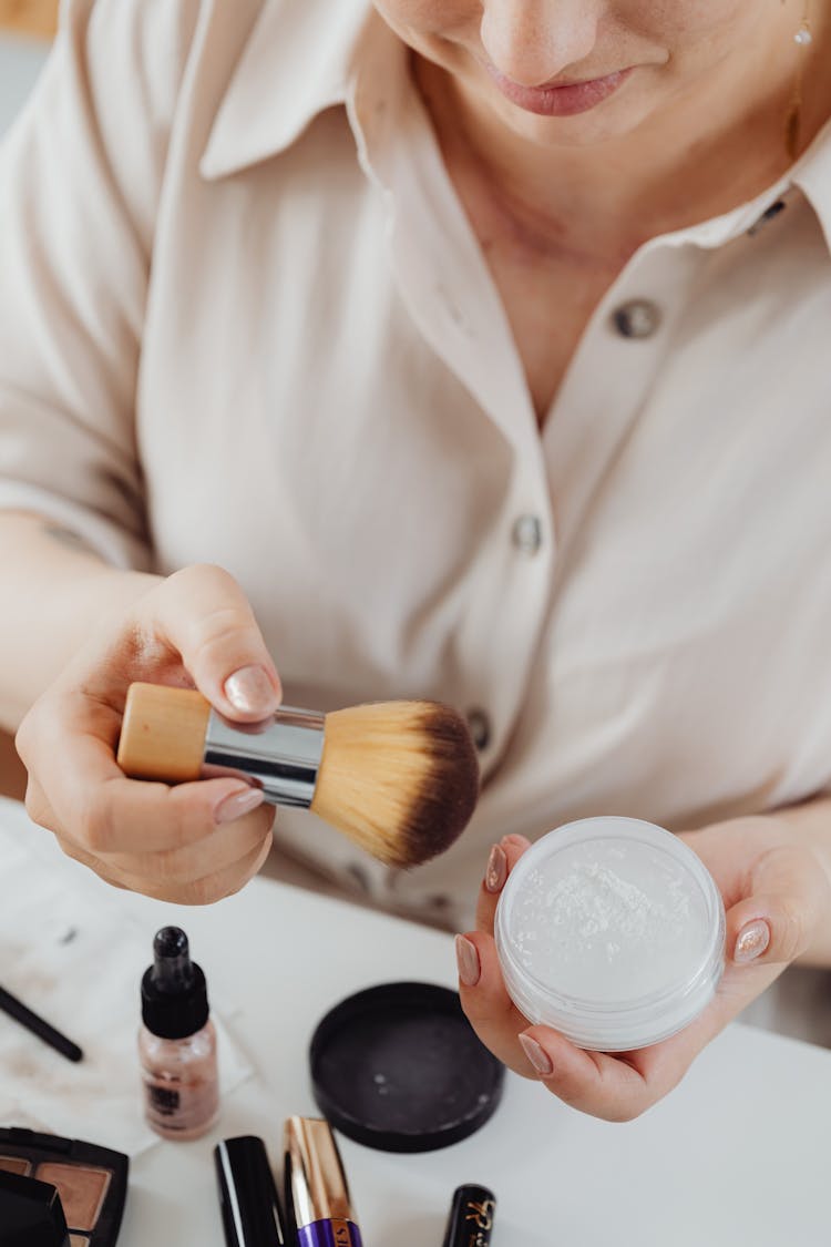 Woman Holding Makeup Brush And Highlighter