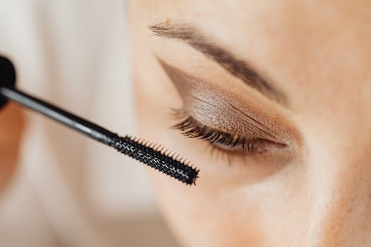 Detailed close-up of mascara application on eyelashes with eyeshadow.
