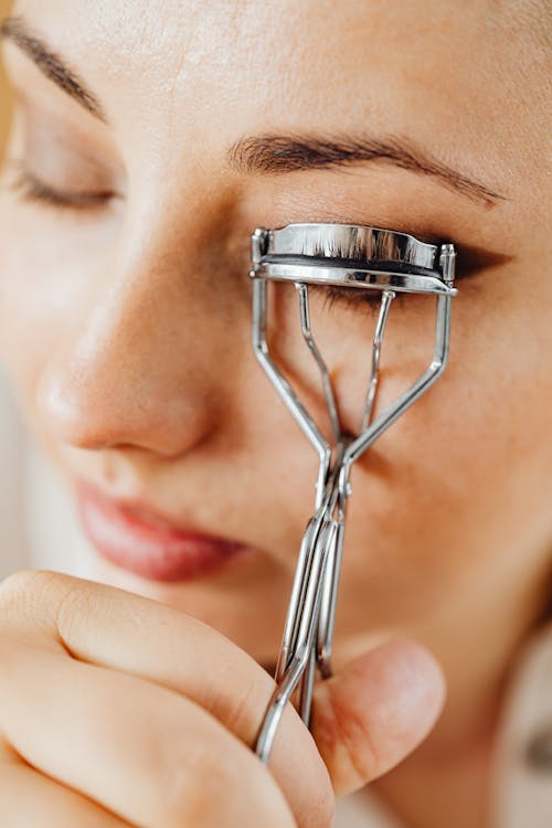 Free A Woman Using Eyelash Curler Stock Photo