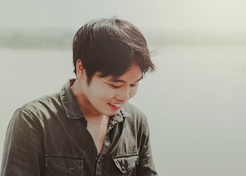 这是一张在柔和阳光下微笑的年轻人的坦率户外肖像