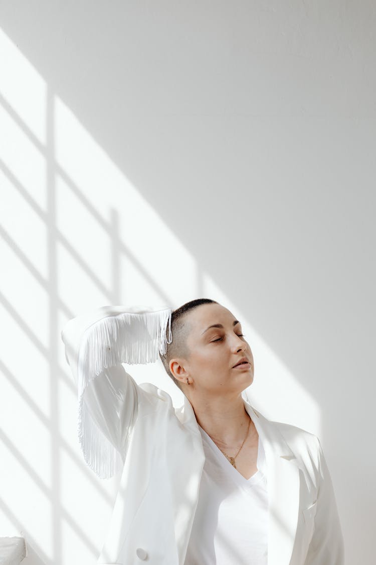 Woman Dressed In White Standing In Sunny Room