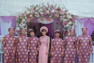 越南传统婚礼上，身着文化服装的人们在花拱下合影