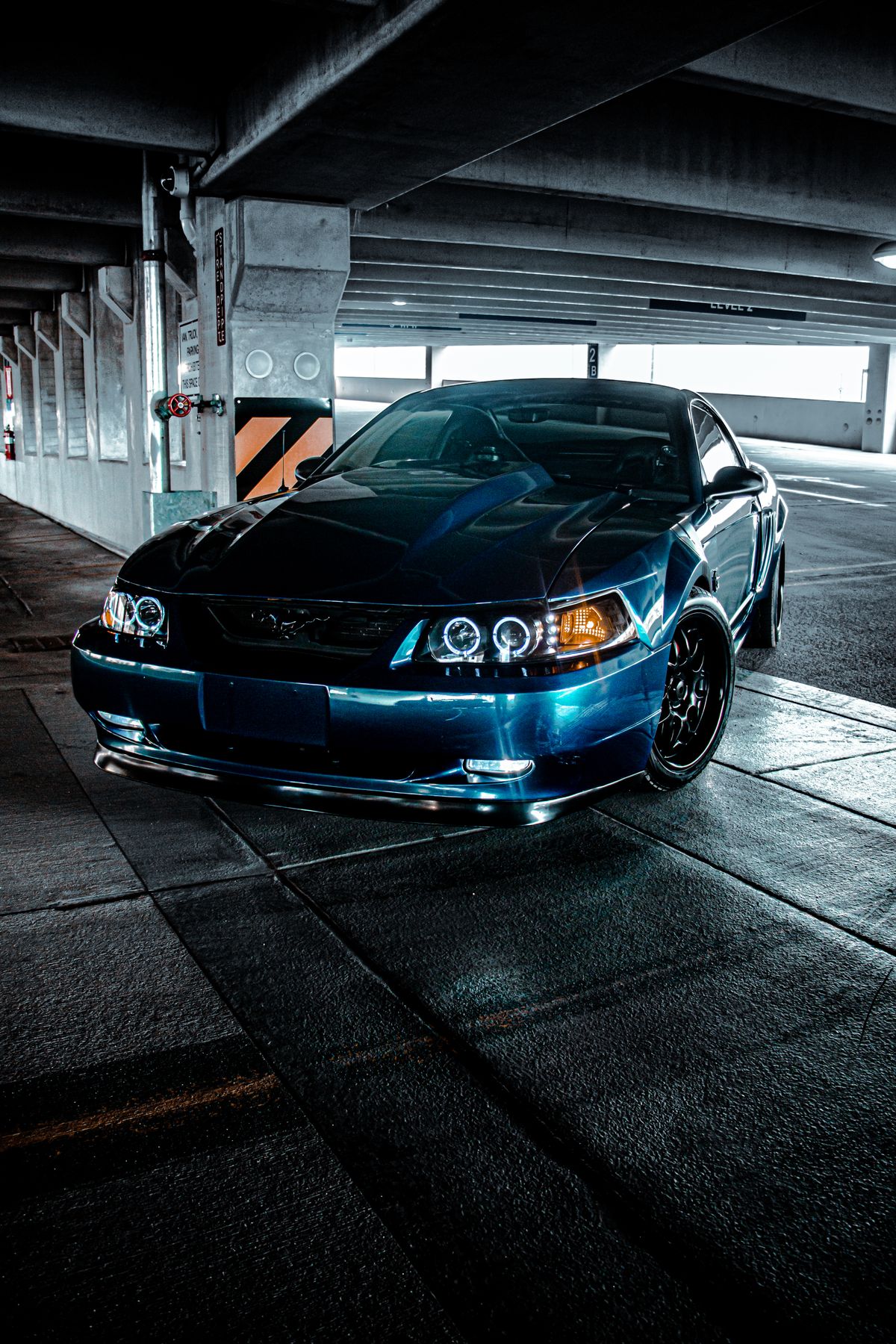 Blue performance car in a shadowed parking structure