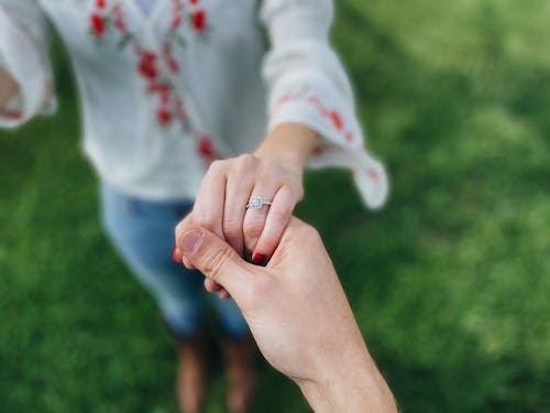Man Holding Woman Hand with Engagement Ring
