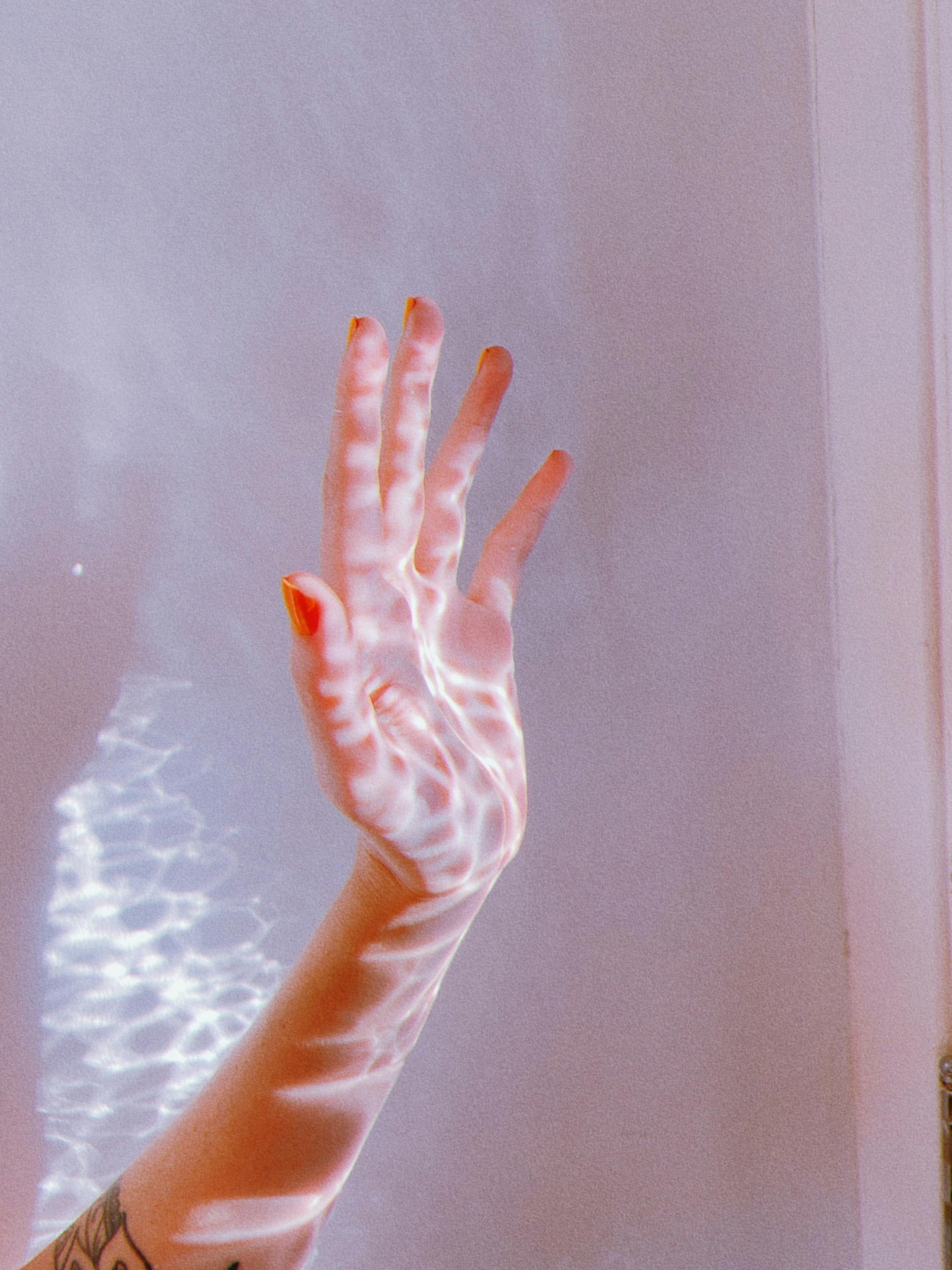 unrecognizable woman with wavy sunlight on hand