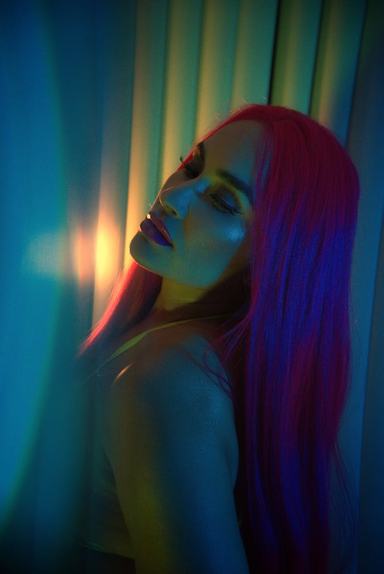 Portrait Of Woman In Pink Hair Under Mood Lighting