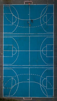 Drone shot of vibrant blue basketball court in Córdoba, Argentina, highlighting sport activities.