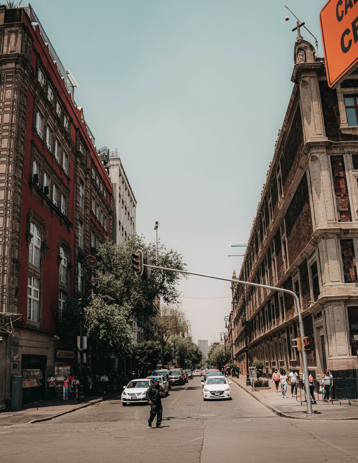 Lively urban street view capturing traffic and pedestrians in Mexico City's historic district.