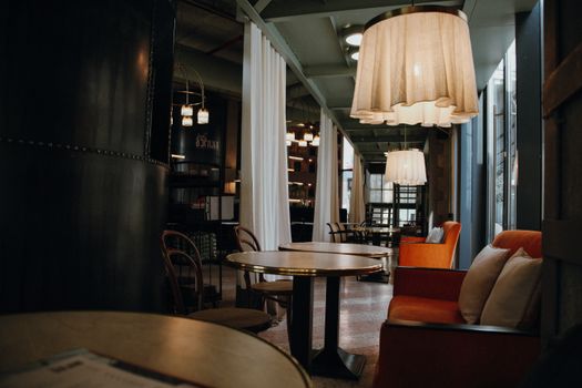 Stylish café interior featuring warm lighting and comfortable seating, perfect for relaxing or working.